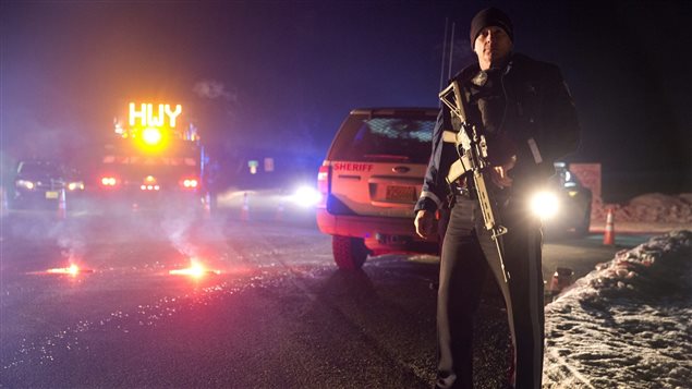 Un policier se tient devant un barrage routier, lors de l'opération policière contre la milice armée près de Burns, en Oregon. Un policier se tient devant un barrage routier, lors de l'opération policière contre la milice armée près de Burns, en Oregon.