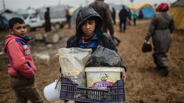 Un enfant transporte quelques effets personnels au camp de Bab Al-Salama, près d'Azaz. Un enfant transporte quelques effets personnels au camp de Bab Al-Salama, près d'Azaz.