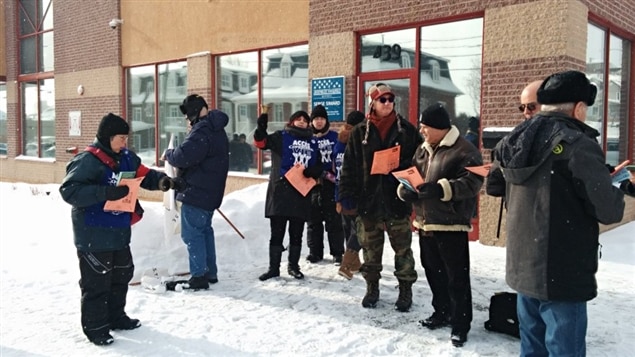 Des gens rassemblés pour manifester devant les bureaux du député Serge Simard afin de dénoncer le projet de loi 70. Des gens rassemblés pour manifester devant les bureaux du député Serge Simard afin de dénoncer le projet de loi 70.