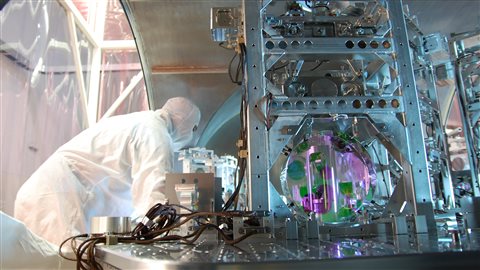 Un chercheur travaille sur l'un des instruments d'un détecteur de l'Observatoire LIGO. Un chercheur travaille sur l'un des instruments d'un détecteur de l'Observatoire LIGO.
