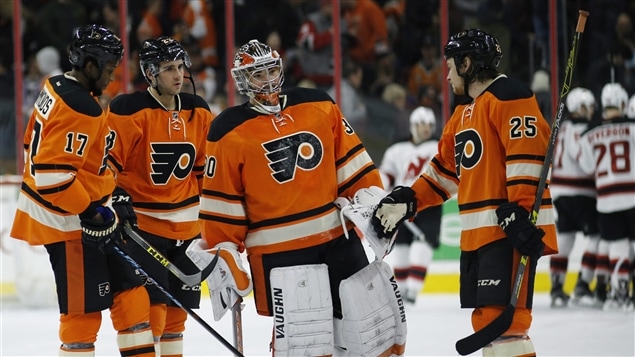 Wayne Simmonds, Brandon Manning et Ryan White félicitent Michal Neuvirth malgré la défaite Wayne Simmonds, Brandon Manning et Ryan White félicitent Michal Neuvirth malgré la défaite