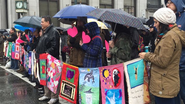 Des dizaines de personnes marchent sous la pluie dans le quartier Downtown Eastside de Vancouver, le 14 février 2016, en hommage aux femmes autochtones disparues ou assassinées.
Des dizaines de personnes marchent sous la pluie dans le quartier Downtown Eastside de Vancouver, le 14 février 2016, en hommage aux femmes autochtones disparues ou assassinées.