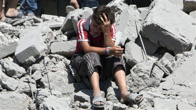 Un jeune syrien pleure parmi les ruines après un tir de missile des forces armées du président Bachar Al-Assad contre un secteur résidentiel de la ville d’Alep, le 21 juillet 2015. Au moins 18 civils ont été tués dans cette attaque. Un jeune syrien pleure parmi les ruines après un tir de missile des forces armées du président Bachar Al-Assad contre un secteur résidentiel de la ville d’Alep, le 21 juillet 2015. Au moins 18 civils ont été tués dans cette attaque.
