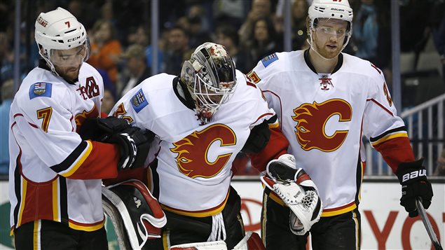 Le gardien des Flames, Karri Ramo, est escorté hors de la patinoire par ses coéquipiers T.J. Brodie et Douggie Hamilton. Le gardien des Flames, Karri Ramo, est escorté hors de la patinoire par ses coéquipiers T.J. Brodie et Douggie Hamilton.