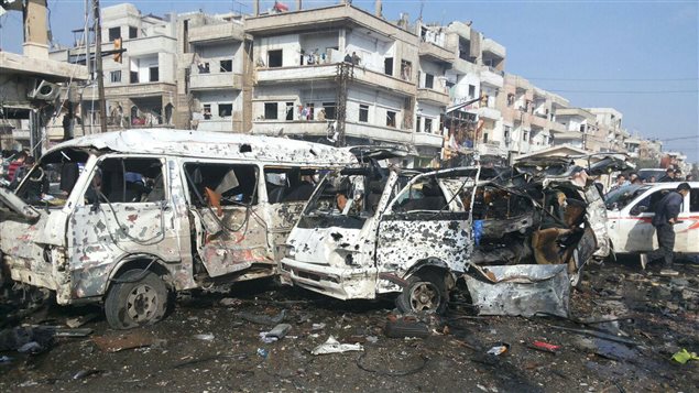 Les carcasses de véhicules détruits par les explosions dans la ville de Homs contrôlée par le gouvernement Les carcasses de véhicules détruits par les explosions dans la ville de Homs contrôlée par le gouvernement