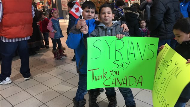 Des réfugiés syriens ont brandi des pancartes faites maison où on peut lire « Les Syriens disent merci au Canada » ou « Merci à tous les Canadiens ». Des réfugiés syriens ont brandi des pancartes faites maison où on peut lire « Les Syriens disent merci au Canada » ou « Merci à tous les Canadiens ».