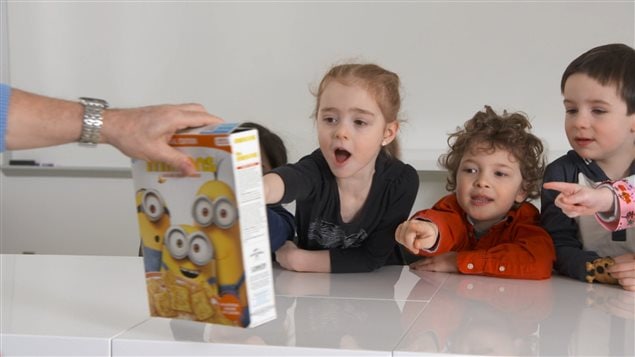 Des enfants réagissent devant une boîte de céréales aux couleurs des Mignons. Des enfants réagissent devant une boîte de céréales aux couleurs des Mignons.