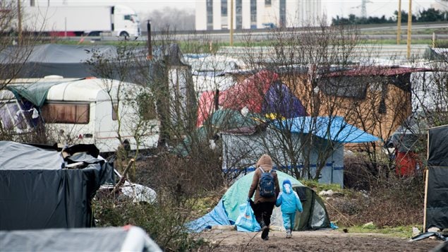 Une migrante marche avec son fils dans la « Jungle » de Calais. Une migrante marche avec son fils dans la « Jungle » de Calais.
