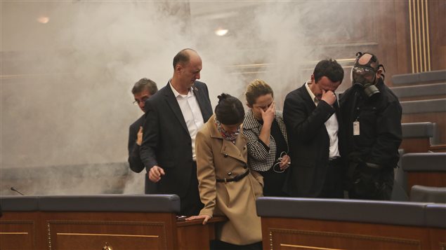Des membres du Parlement du Kosovo incommodés par du gaz lacrymogène lors de la séance d'élection du président Hashim Thaci. Des membres du Parlement du Kosovo incommodés par du gaz lacrymogène lors de la séance d'élection du président Hashim Thaci.