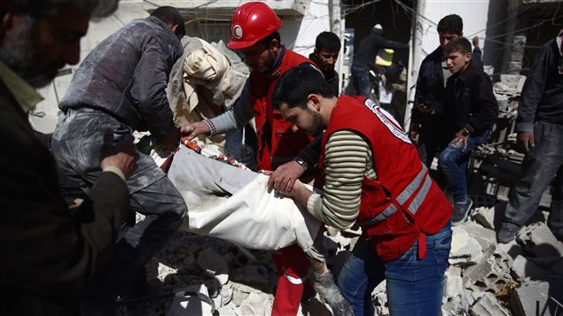 Des membres du Croissant rouge arabe syrien extirpent un corps des décombres, vendredi, à Douma. Des membres du Croissant rouge arabe syrien extirpent un corps des décombres, vendredi, à Douma.