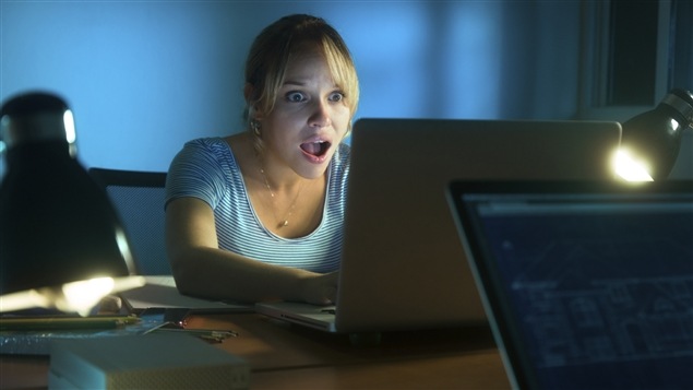 Une jeune femme vit des émotions fortes en consultant Facebook. Une jeune femme vit des émotions fortes en consultant Facebook.