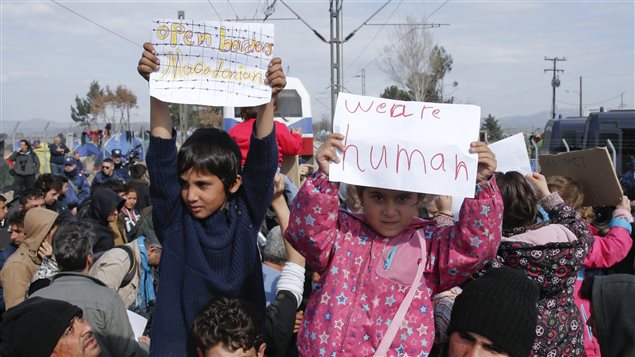 « Macédoniens, ouvrez les frontières » et « Nous sommes humains », clament ces deux enfants de migrants par l'intermédiaire de leurs affichettes. « Macédoniens, ouvrez les frontières » et « Nous sommes humains », clament ces deux enfants de migrants par l'intermédiaire de leurs affichettes.
