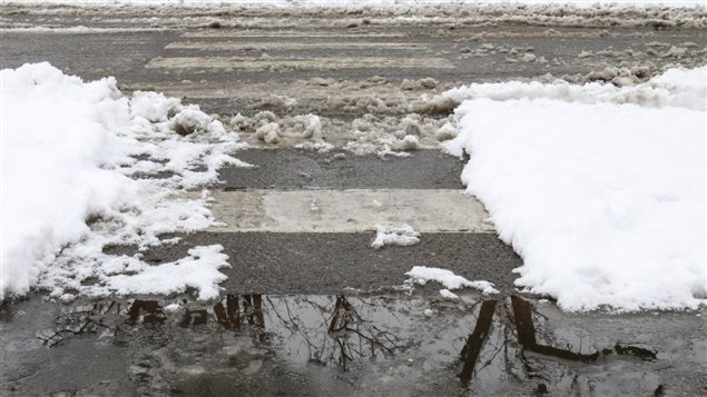 Un passage piétonnier avec de la neige fondue, de l'eau et de la glace. Un passage piétonnier avec de la neige fondue, de l'eau et de la glace.