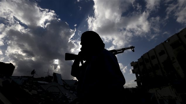 Un rebelle syrien transporte son arme sur son épaule. Un rebelle syrien transporte son arme sur son épaule.