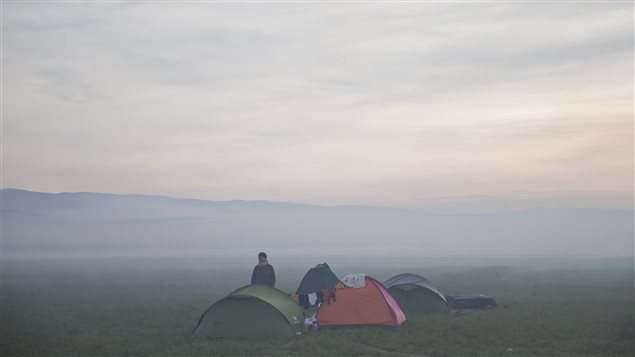 Un réfugié se tient près de sa tente, en attente de pouvoir entrer en territoire macédonien. Un réfugié se tient près de sa tente, en attente de pouvoir entrer en territoire macédonien.