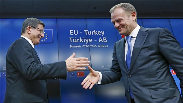 Le premier ministre turc Ahmet Davutoglu sert la main du président du Conseil européen Donald Tusk à l'issue du sommet à Bruxelles, le 8 mars 2016. Le premier ministre turc Ahmet Davutoglu sert la main du président du Conseil européen Donald Tusk à l'issue du sommet à Bruxelles, le 8 mars 2016.