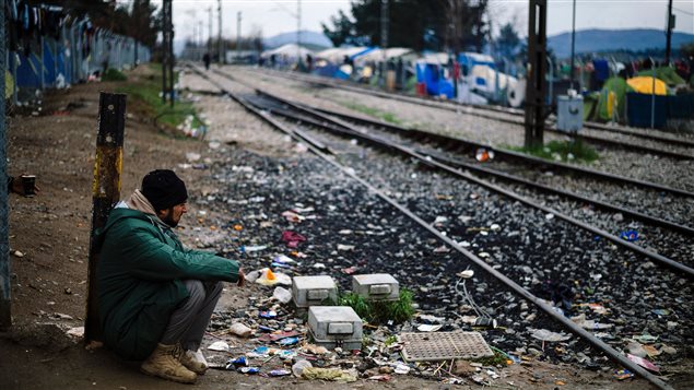 Un migrant est assis le long de la voie ferrée qui relie la Grèce et la Macédoine. Un migrant est assis le long de la voie ferrée qui relie la Grèce et la Macédoine.