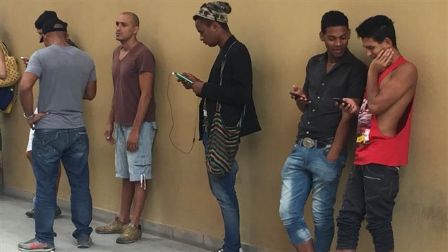 Des Cubains connectés à un réseau wi-fi à La Havane Des Cubains connectés à un réseau wi-fi à La Havane