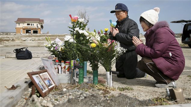 Des parents prient pour leur fille qui a perdu la vie dans la catastrophe de Fukushima. Des parents prient pour leur fille qui a perdu la vie dans la catastrophe de Fukushima.