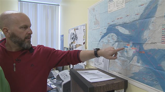Gil Thériault, directeur de l'Association des chasseurs de phoques des Îles-de-la-Madeleine pointe une carte.