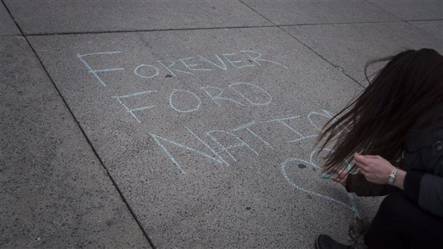 Une résidente laisse un message de condoléances à la craie pour Rob Ford sur la place de l'hôtel de ville. Une résidente laisse un message de condoléances à la craie pour Rob Ford sur la place de l'hôtel de ville.