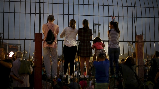 De jeunes spectateurs s'accrochent même à la barrière pour mieux voir la scène. De jeunes spectateurs s'accrochent même à la barrière pour mieux voir la scène.
