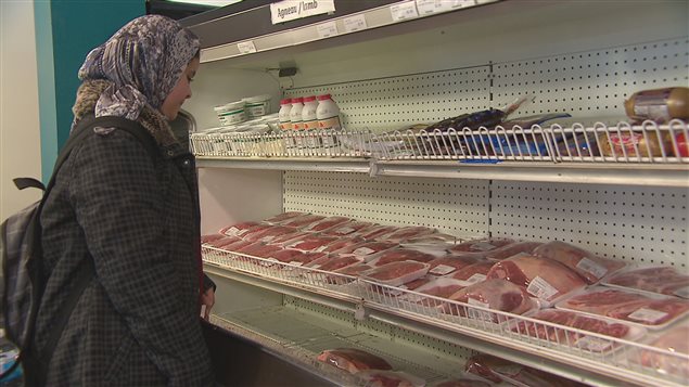 Une dame devant un étalage de viande halal Une dame devant un étalage de viande halal