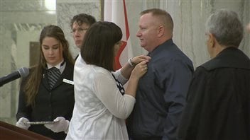 La députée Nicole Goehring remet le ruban de couleur sarcelle à Dan Matheson. La députée Nicole Goehring remet le ruban de couleur sarcelle à Dan Matheson.