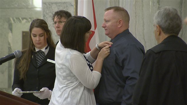 La députée Nicole Goehring remet le ruban de couleur sarcelle à Dan Matheson. La députée Nicole Goehring remet le ruban de couleur sarcelle à Dan Matheson.