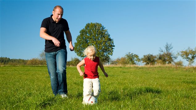 Un père joue au ballon avec sa fille
