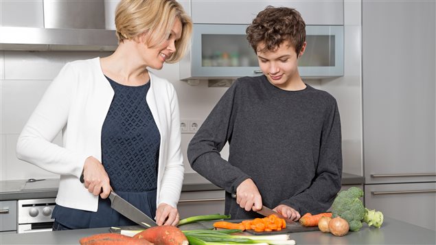 Une mère et son fils cuisinent ensemble.