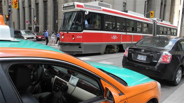 Tramway et taxi dans la circulation au centre-ville de Toronto. Tramway et taxi dans la circulation au centre-ville de Toronto.