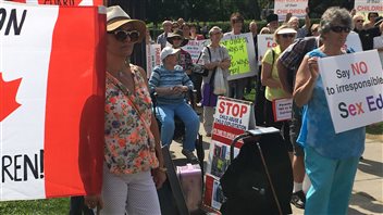 Des gens manifestent contre le programme d'éducation sexuelle de la province devant Queen's Park. Des gens manifestent contre le programme d'éducation sexuelle de la province devant Queen's Park.