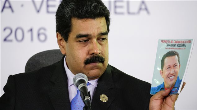 Le président Maduro tenant un livre portant le portrait de son idole, Hugo Chavez Le président Maduro tenant un livre portant le portrait de son idole, Hugo Chavez