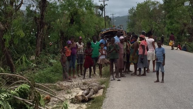Des gens se recueillent autour d'une victime de l'ouragan Matthew.