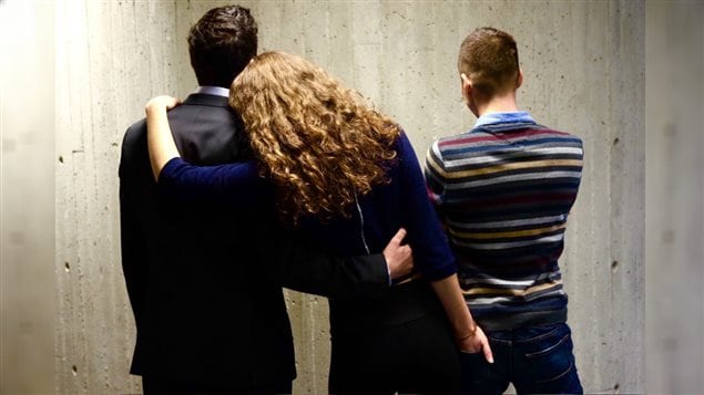 Une femme polyamoureuse enlace deux hommes Une femme polyamoureuse enlace deux hommes