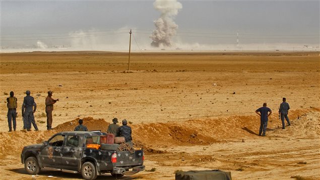 Des soldats irakiens positionnés à environ 45 km au sud de Mossoul observent une colonne de fumée qui s'échappe d'un village. Des soldats irakiens positionnés à environ 45 km au sud de Mossoul observent une colonne de fumée qui s'échappe d'un village.