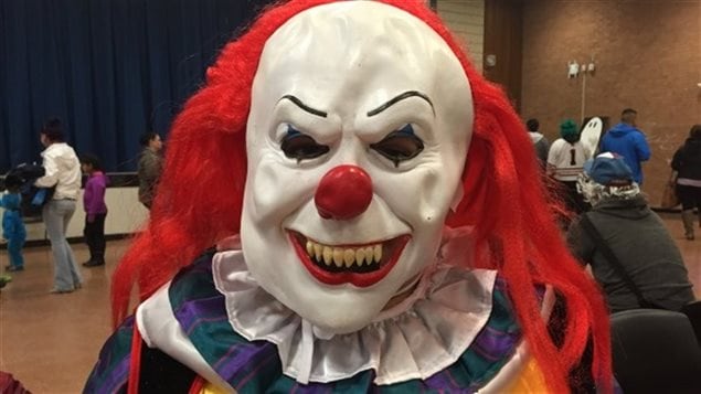 Une personne portant un masque de clown effrayant. Une personne portant un masque de clown effrayant.