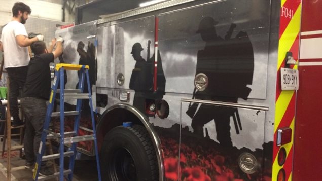 Des graphistes finissent d'orner un camion de pompier d'un décalque pour honorer le 100e anniversaire de la bataille de Vimy. Des graphistes finissent d'orner un camion de pompier d'un décalque pour honorer le 100e anniversaire de la bataille de Vimy.