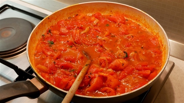 Une poêle sur une cuisinière contient de la sauce tomate Une poêle sur une cuisinière contient de la sauce tomate