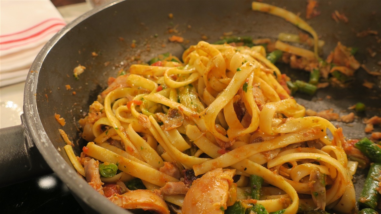 Des fettucines au poulet, tomates et légumes dans une poêle Des fettucines au poulet, tomates et légumes dans une poêle