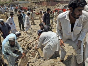 Des Pakistains cherchent des victimes sous les décombres. Des Pakistains cherchent des victimes sous les décombres.