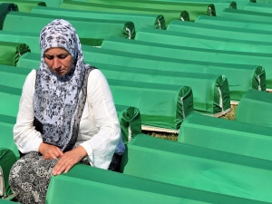 Une femme se recueille devant le cercueil d'un de ses proches. Une femme se recueille devant le cercueil d'un de ses proches.