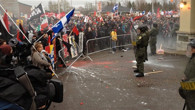 Des manifestants séparés des policiers par une barricade à Victoriaville Des manifestants séparés des policiers par une barricade à Victoriaville