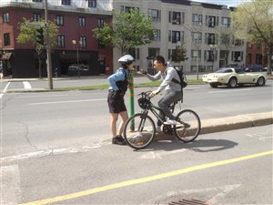 Une policière du Service de police de la Ville de Montréal discute avec un cycliste de l'importance du port du casque, dans le cadre d'une opération de sensibilisation. Une policière du Service de police de la Ville de Montréal discute avec un cycliste de l'importance du port du casque, dans le cadre d'une opération de sensibilisation.