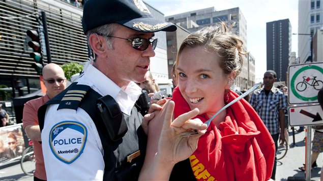 Un policier repousse une manifestante sur la rue Crescent, à Montréal, pendant le Grand Prix. Un policier repousse une manifestante sur la rue Crescent, à Montréal, pendant le Grand Prix.