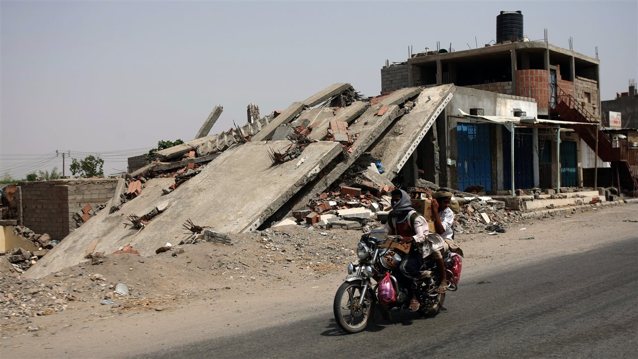 Des hommes circulent à moto devant un bâtiment effondré après l’offensive de l’armée à Jaar. Des hommes circulent à moto devant un bâtiment effondré après l’offensive de l’armée à Jaar.