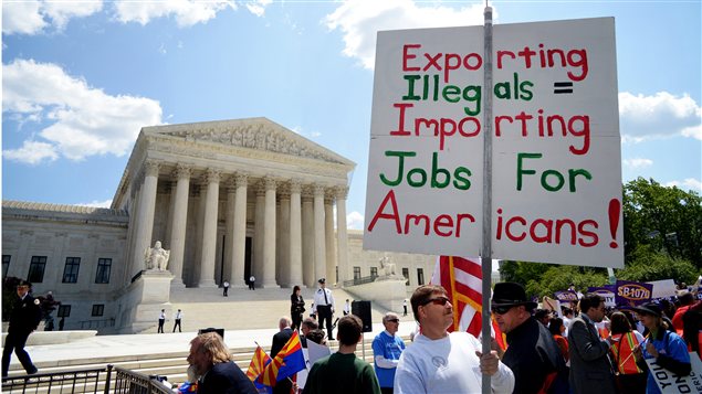 Un homme appuyant la loi de l'Arizona sur l'immigration clandestine faisait passer son message devant la Cour suprême, à Washington. Un homme appuyant la loi de l'Arizona sur l'immigration clandestine faisait passer son message devant la Cour suprême, à Washington.