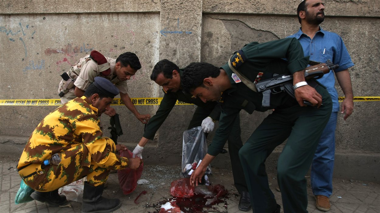 Des policiers et militaires yéménites récoltent des indices sur le lieu d'un attentat suicide, à Sanaa. Des policiers et militaires yéménites récoltent des indices sur le lieu d'un attentat suicide, à Sanaa.