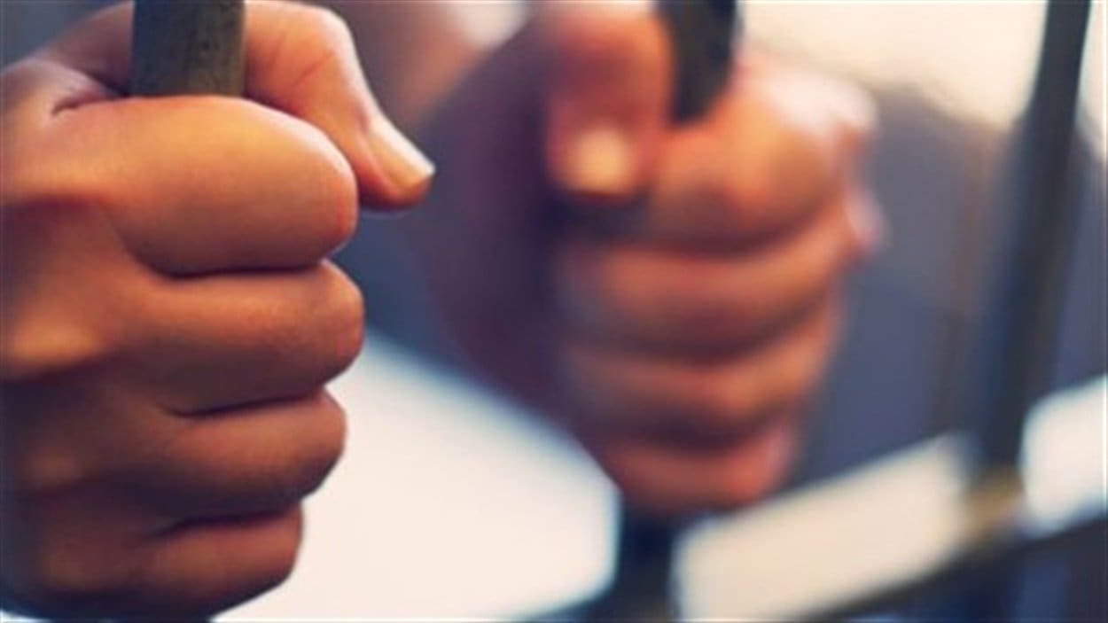 Les mains d'un détenu sur les barreaux d'une cellule Les mains d'un détenu sur les barreaux d'une cellule